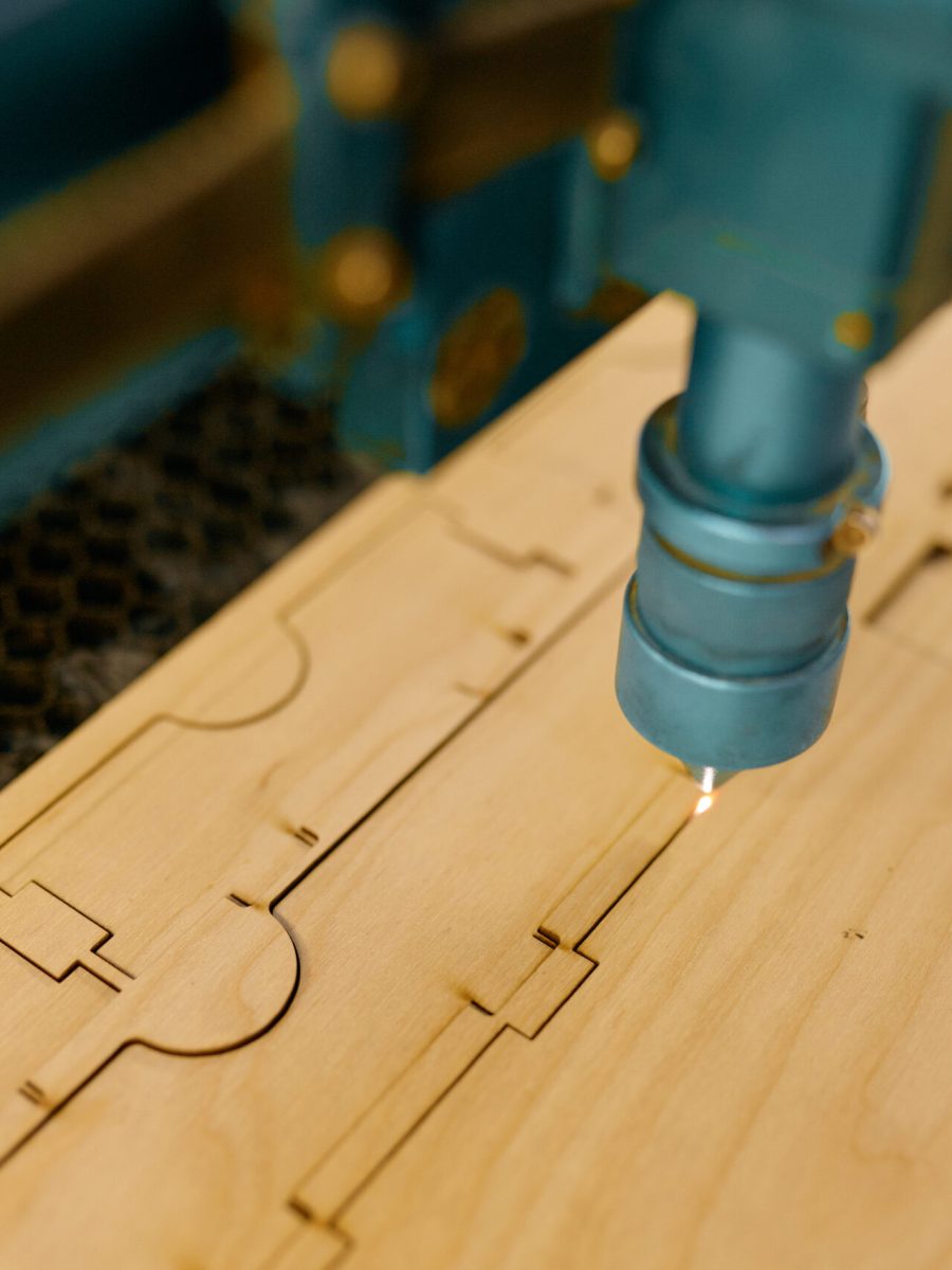 Closeup automated CNC laser machine operating with wooden plank. Woodworking, cutting and engraving process